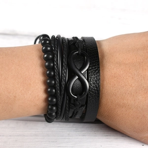 Close-up of black layered leather bracelet featuring infinity symbol and braided rope