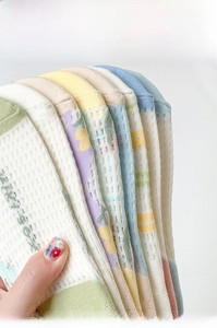 Détail de chaussettes en coton respirant aux couleurs macaron avec motifs floraux