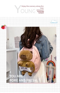 Detail of pink backpack featuring a 3D plush capybara and transparent front PVC pocket