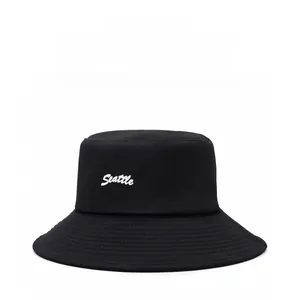 Close-up of white Seattle embroidery and reinforced stitching on a black bucket hat