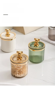 Detail of luxury storage jars with gold bear lids and elegant vertical striped texture