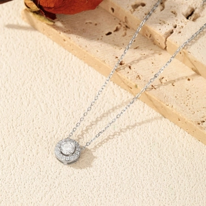 Collier classique rond en moissanite et argent 925 sur fond texturé élégant