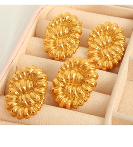 Detailed view of vintage gold-plated twist earrings placed in a jewelry organizer tray
