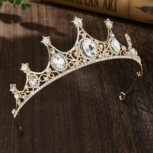 Detailed close-up of golden crown with sparkling crystals on vintage wooden surface