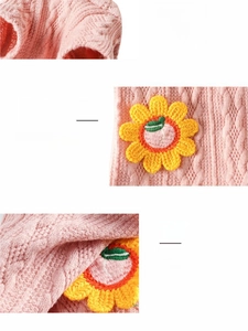 Close-up detail of pink cable knit dog sweater with embroidered sunflower floral patterns