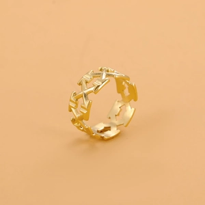 Detail of elegant gold hollow arrow and X-shaped geometric pattern on a polished metal ring