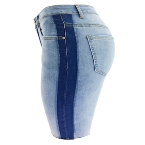 Détail de short en jean bleu clair avec bandes latérales foncées et bords d'ourlet effilochés