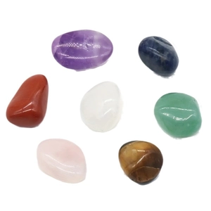Ensemble de sept pierres naturelles de chakra polies incluant améthyste sur fond blanc