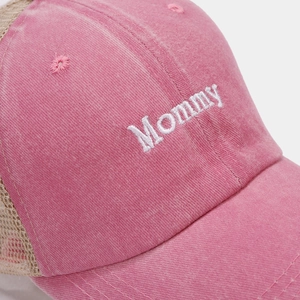 Close-up of Mommy embroidery on washed pink cotton fabric with breathable mesh detail
