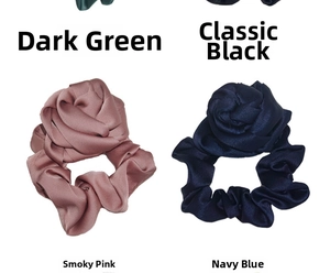 Detail of rose-shaped hair scrunchies in dark green, black, pink, and navy satin silk