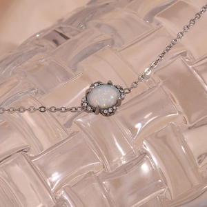 Detailaufnahme einer Silberkette mit ovalem weißem Opal und Zirkon-Akzenten