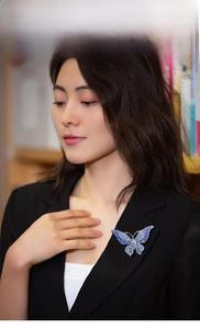 Blue crystal butterfly brooch accessory pinned on a black suit jacket for model display
