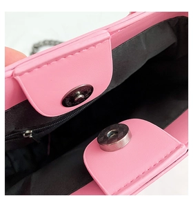 Detail showing pink punk handbag interior with magnetic closure and black zipper pocket