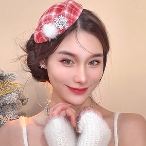Detail view of red plaid beret hair clip with white plush ball and rhinestone snowflake