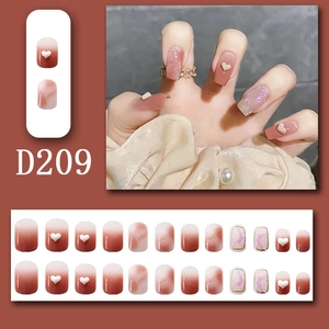 Detail of red marble press-on nails with 3D white hearts and gold accents, model D209