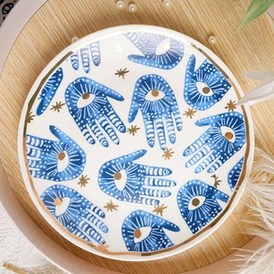 Draufsicht auf eine Keramik-Schmuckschale mit blauen Hamsa-Hand-Mustern und Goldrand