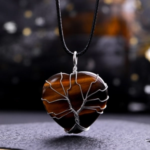Macro detail of heart-shaped tiger eye stone pendant with silver tree of life wire wrapping