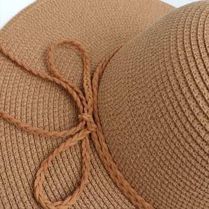 Close-up of hand-woven straw hat showing fine spiral texture and braided rope detail