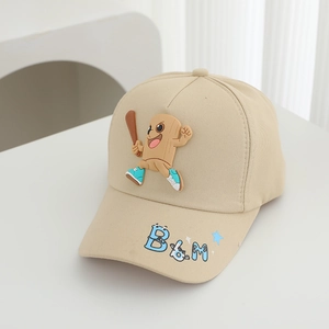 Detail of cartoon character silicone patch on a beige kids cotton baseball cap