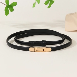 Slim black patent leather belt for women with elegant gold buckle on a beige surface