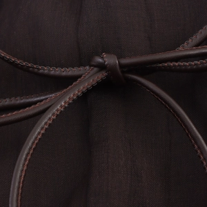 Detail of elegant brown chiffon dress featuring a thin faux leather drawstring with stitching