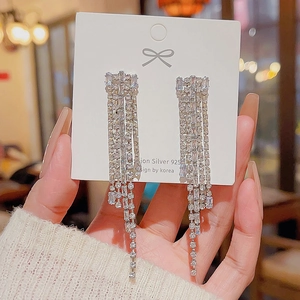 Close-up of sparkling silver tassel earrings with rhinestones on 925 silver needle card