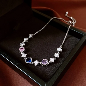 Macro shot of silver bracelet with zircon flowers and pink, blue, purple gemstones
