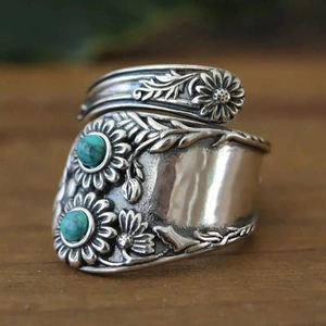 Vintage sunflower silver spoon ring with turquoise stones on rustic wood background
