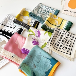 Collection of multi-colored printed silk scarves in various floral and geometric patterns