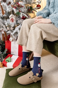 Calze natalizie blu navy con motivi Babbo Natale in un accogliente ambiente festivo