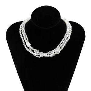 Close-up of triple-layered pearl necklace with baroque style charms on black display
