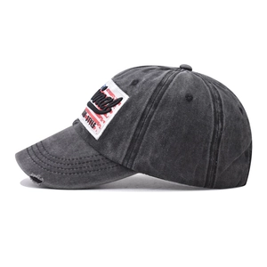 Close-up of distressed washed black cotton baseball cap with Honey embroidery and torn brim