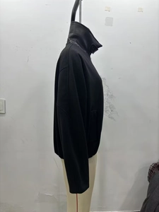 Detailed side view of black street fashion jacket with contrasting shiny stand-up collar