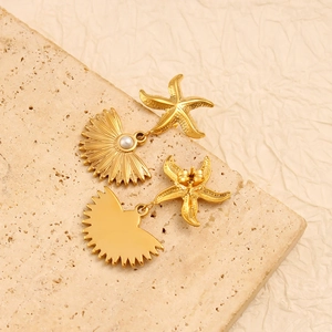 Detailed close-up of golden starfish and fan-shaped seashell earrings with white pearls