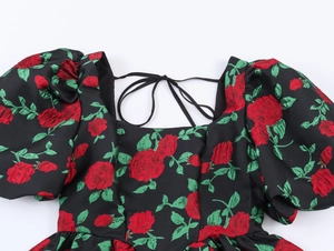 Détail du col carré et des manches bouffantes avec jacquard fleuri rouge sur noir