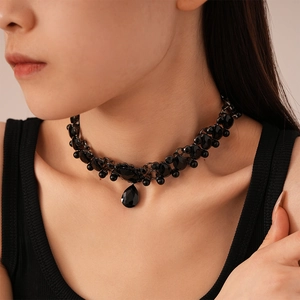 Detail of a vintage layered black beaded choker with a faceted water drop pendant