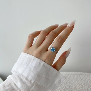 Detail of S925 silver ring featuring a large square blue zircon on a model's hand