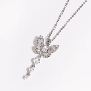 Détail du collier papillon en argent avec des pompons en zircone sur fond blanc