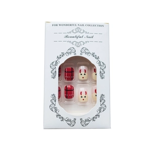 Christmas press-on nails set featuring red plaid and reindeer designs in a white box