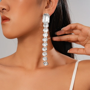 Close-up of luxury rectangular acrylic rhinestone tassel earrings on a model