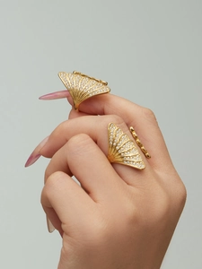 Detail of gold zircon shell open rings with intricate pave setting on model hands
