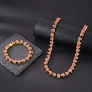 Detail of gold Cuban chain set with pink pavé crystals and heart links