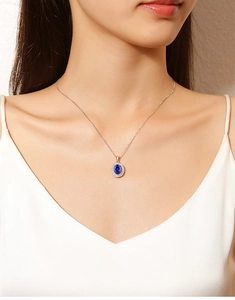 Close-up of S925 silver necklace with blue radiant cut tanzanite pendant on model