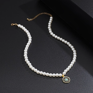 Men's pearl necklace with a gold sun pendant and turquoise stone on a black background