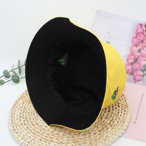 Detail of yellow and black bucket hat featuring a colorful cactus embroidery design