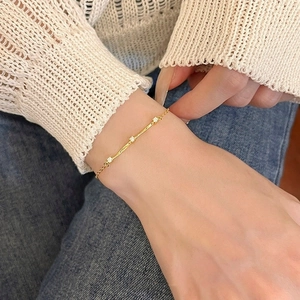 Close-up of minimalist Mobius S925 sterling silver gold bracelet with sparkling diamonds