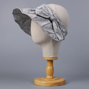 Close-up of gray fabric sun hat with elegant bow detail and jacquard texture