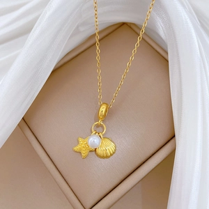 Detail of gold starfish shell and pearl pendant on a luxury titanium steel necklace