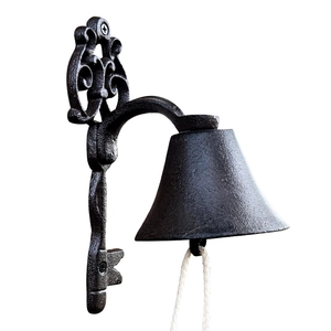 Vintage cast iron doorbell with ornate scrollwork bracket and cotton rope for garden