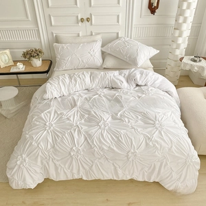 Detail of white 3D textured pinch pleat bedding set with floral tufted pattern